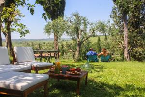 un hombre y una mujer sentados en sillas en la hierba en Agriturismo Quarantallina, en Buonconvento