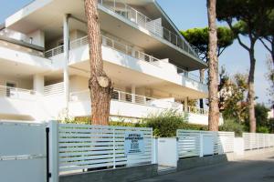 a white building with a fence in front of it at Casa Baroncini Appartamenti in Cervia