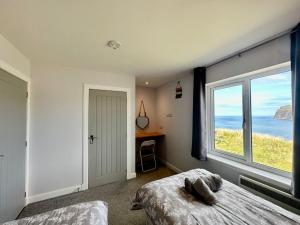 a bedroom with a bed and a view of the ocean at Eas Mor in Glendale