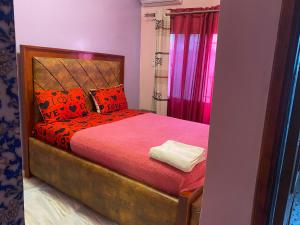 una camera da letto con un letto con cuscini rossi e arancioni di Gloton apartments a Sere Kunda
