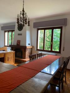 een grote eettafel met stoelen en een open haard bij B&B Casa Gaia in Meano