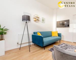 een woonkamer met een blauwe bank en een vloerlamp bij 5-10 Off Weekly-Monthly Stays for Groups, Family Relocation, Contractors or Corporate bookings in Northampton