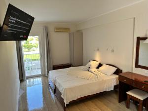 ein Schlafzimmer mit einem Bett und einem TV. in der Unterkunft Aggelos Family Hotel in Moraḯtika