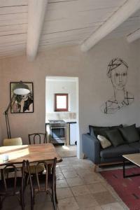 a living room with a table and a couch at La petite maison des artistes in Séguret