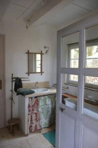 baño blanco con lavabo y ventana en La petite maison des artistes, en Séguret