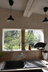 a kitchen with a sink and a window at La petite maison des artistes in Séguret