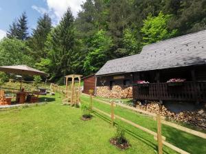 un granero con una valla delante de un patio en Waldhütte Glück Auf, en Nötsch bei Bleiberg