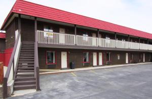 a building with a red roof and a parking lot at Travelers Lodge in West Yellowstone