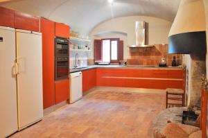 - une cuisine avec des armoires orange et un réfrigérateur blanc dans l'établissement Torre Bertrana By Duquessa Hotel Collection, à Pals