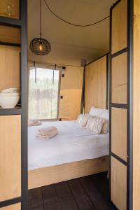a bed in a small room with a window at Vakantie plezier Vlaanderen in Zedelgem