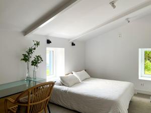 Dormitorio blanco con cama y mesa de cristal en seixurra 31, en A Coruña