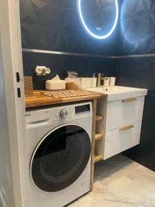 een keuken met een wasmachine en een wastafel bij Blue Haven Sèvres in Sèvres