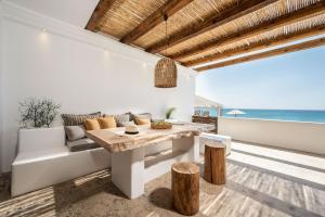 a living room with a table and a couch and the ocean at Euphoria Suites and Spa in Kardamaina