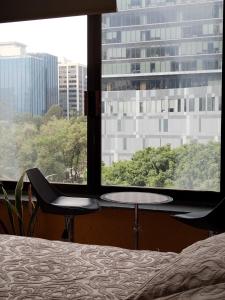 1 dormitorio con cama, mesa y ventana en Loft Corredor Financiero Reforma, en Ciudad de México