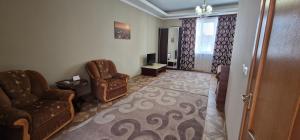 a living room with two chairs and a television at Chernivtsi Apartments in Chernivtsi