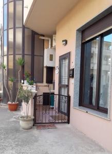 una porta d'ingresso di una casa con piante in vaso di Radici Blu intero alloggio a Siderno Marina