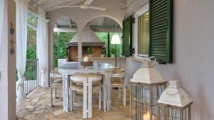 porche con mesa y sillas en el patio en Kanakades Olive Cottage, en Kanakádes