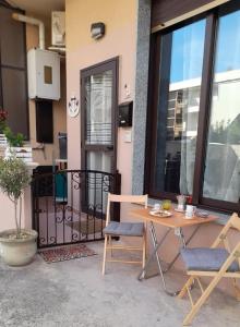 un patio con tavolo e sedie di fronte a un edificio di Radici Blu intero alloggio a Siderno Marina