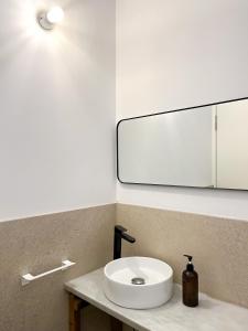 ein Badezimmer mit einem weißen Waschbecken und einem Spiegel in der Unterkunft seixurra 31 in A Coruña