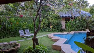 a backyard with a swimming pool and a tree at Ben Bali Villa in Seminyak