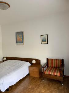 een slaapkamer met een bed en een stoel bij B&B Casa Gaia in Meano