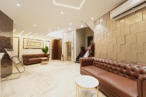 een lobby met bruin lederen meubilair en een trap bij HOTEL AJMER SHERATON in Ajmer