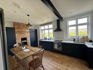 a kitchen with a wooden table and a dining room at Stylish Unique 3 Bedroom House Hastings in Hastings
