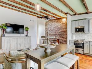 a living room with a wooden table and a kitchen at Gordon Inn Tree Top in Savannah