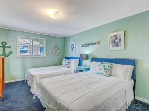two beds in a room with green walls at Bikini Top & Bottom in Tybee Island