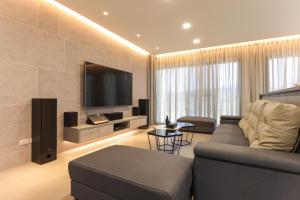 a living room with a couch and a flat screen tv at Yonezawa Guest House in Magong