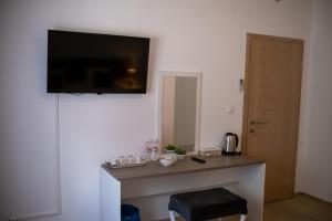 Villa Mir في موستار: غرفة مع طاولة وتلفزيون على الحائط