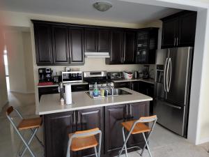 a kitchen with black cabinets and a counter with chairs at Beautiful Master Bedroom, TV, Wi-fi, Laundry, Parking in Cambridge