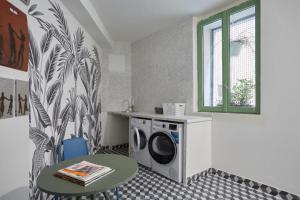 a laundry room with a washing machine and a table at Art Lovers Apart Floor 2 in Béziers