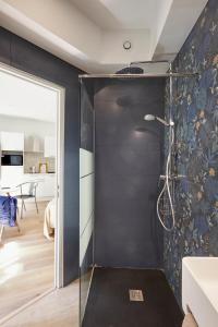a shower in a bathroom with a black wall at Art Lovers Apart Floor 2 in Béziers