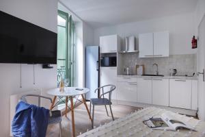 a kitchen with white cabinets and a table and chairs at Art Lovers Apart Floor 2 in Béziers