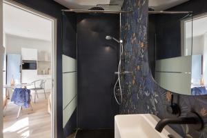 a bathroom with black walls and a shower and a sink at Art Lovers Apart Floor 2 in Béziers +10 photos