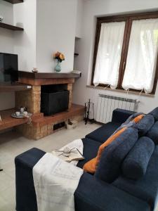 sala de estar con sofá azul y TV en La casina delle viole en Abbadia San Salvatore
