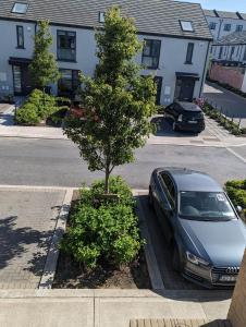 une voiture garée dans un parking à côté d'un arbre dans l'établissement New House, Private Rooms in a Peaceful Neighborhood, à Dublin