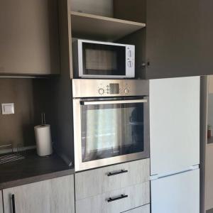 a kitchen with a microwave and a refrigerator at Μοντέρνο διαμέρισμα στη Βέροια (LIBERTY) in Veria