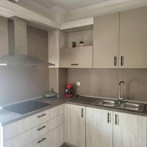 a kitchen with white cabinets and a sink at Μοντέρνο διαμέρισμα στη Βέροια (LIBERTY) in Veria