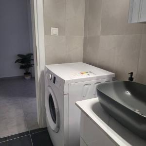 a bathroom with a washing machine and a sink at Μοντέρνο διαμέρισμα στη Βέροια (LIBERTY) in Veria