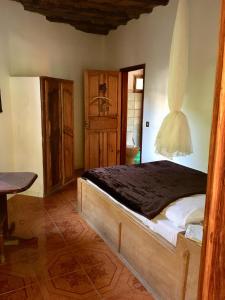 ein Schlafzimmer mit einem Bett und einem Tisch in einem Zimmer in der Unterkunft Karamba Lodge in Kafountine