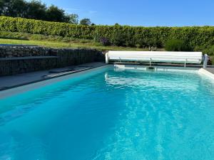 Una piscina de agua azul con un banco. en Le Cocon Nocturne 10min Arkema Total en Macheren