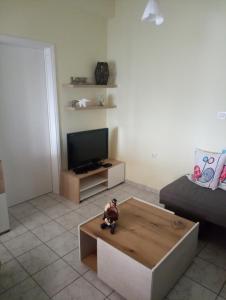 a living room with a tv and a coffee table at Votsalo Apartment in Kavála
