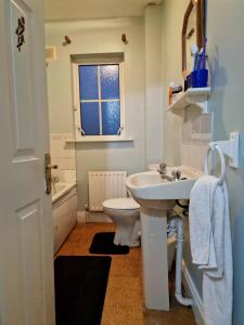 La salle de bains blanche est pourvue d'un lavabo et de toilettes. dans l'établissement Females Only - Private Bedrooms in Dublin, à Lucan