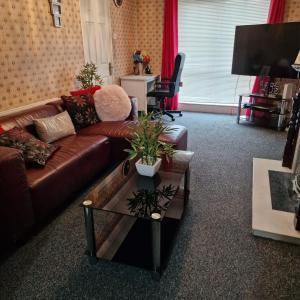 ein Wohnzimmer mit einem braunen Sofa und einem Couchtisch in der Unterkunft Females Only - Private Bedrooms in Dublin in Lucan