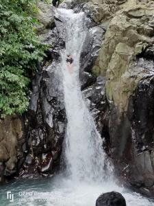 a person standing in the middle of a waterfall at D'kailash Retreat in Singaraja