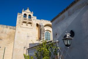 un edificio con una torre dell'orologio e un lampione di GoodStay Central Suite -Terrace & Charme- a Lecce