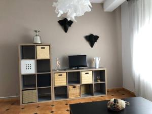 a living room with a tv and a book shelf at Piso Costa Da Morte_Camariñas in Camariñas