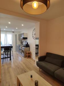 a living room and kitchen with a couch and a table at Moderne et chaleureux duplex en centre-ville in Saint-Jean-de-Védas